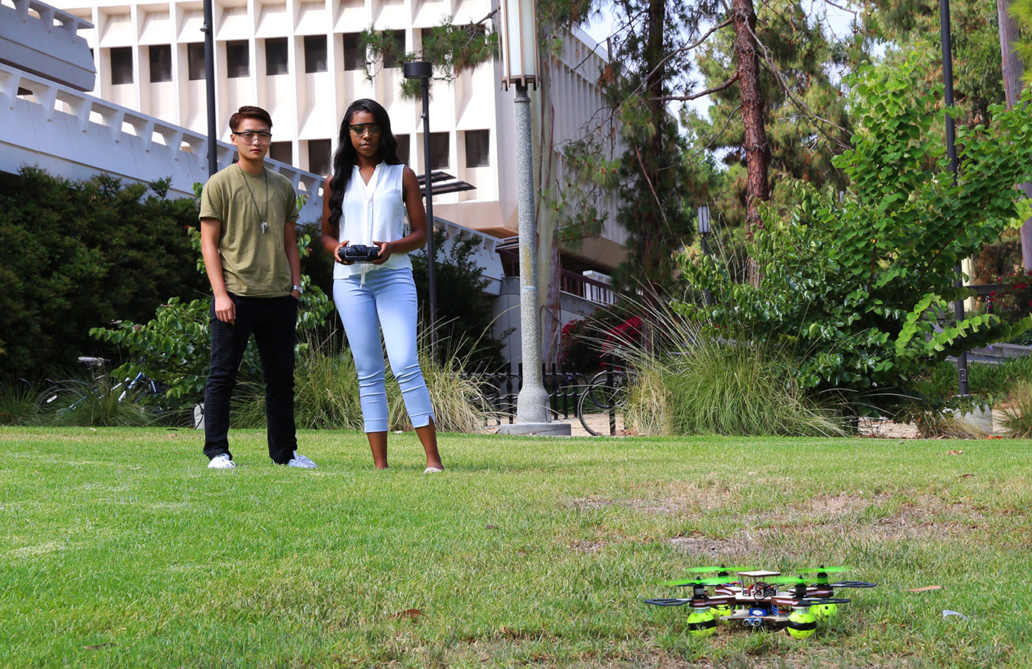 Two UCI students work on drones they built and programmed.