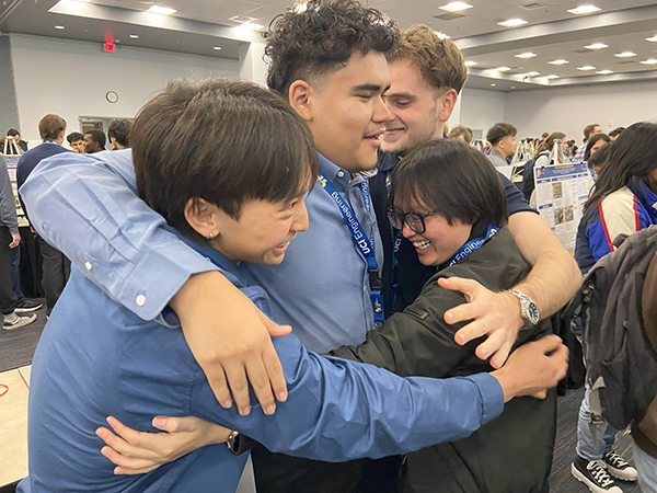 Team members from Project Prometheus, a wildfire detection system, go all in for a group hug after winning a Dean’s Choice Award. 