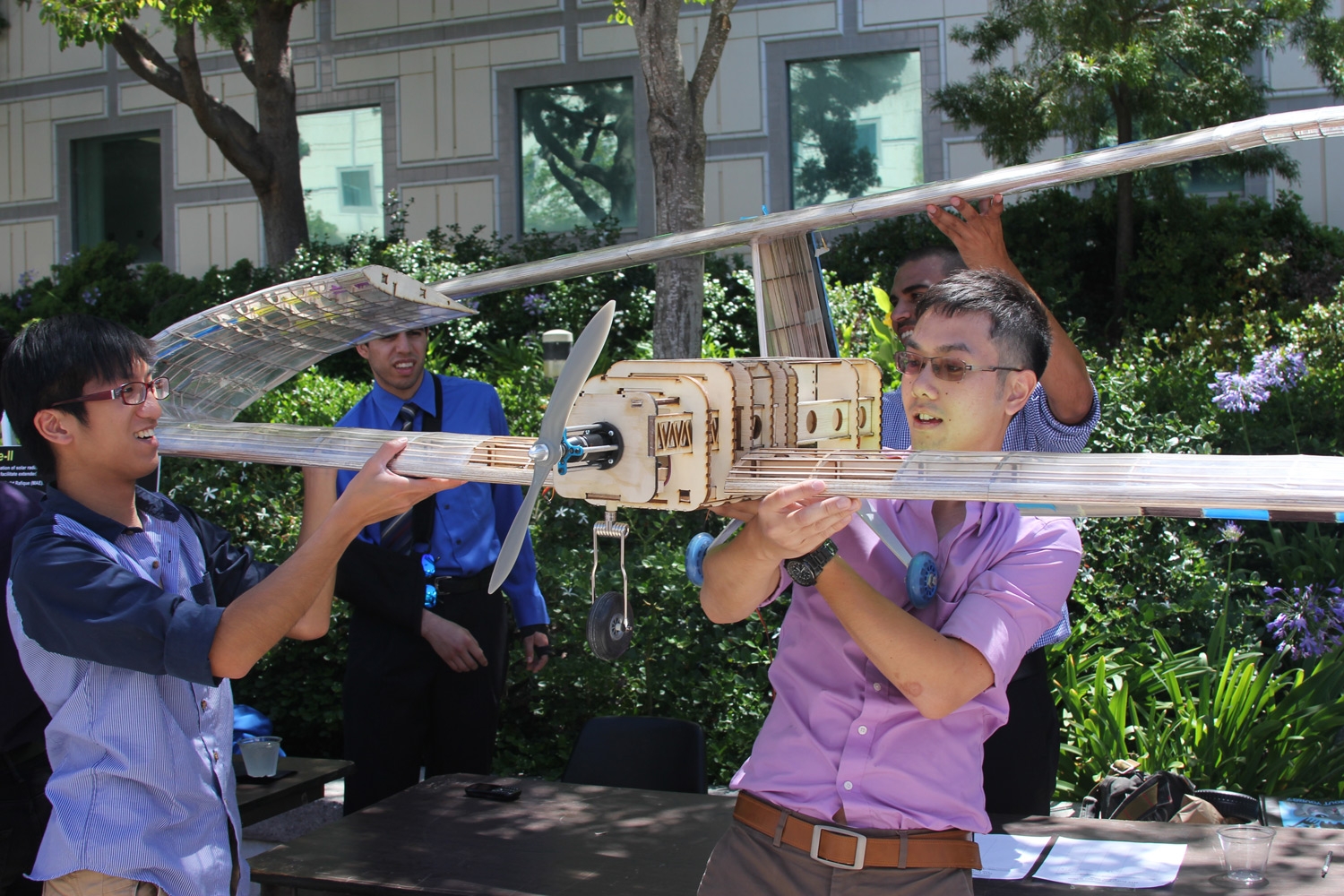 Students holding up a small scale airplane