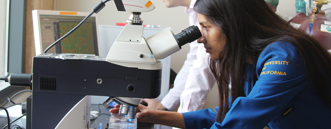 Female scientist looks into microscope