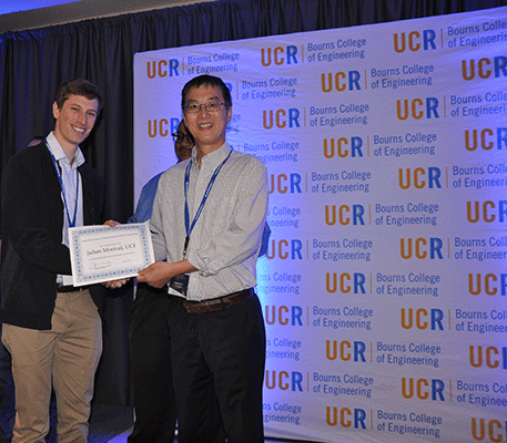 Morival (left) accepts his best poster award from Xiaoping Hu, professor and chair of UC Riverside’s Department of Bioengineering. 