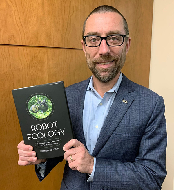 Magnus Egerstedt, Stacey Nicholas Dean of the Henry Samueli School of Engineering, with his new book “Robot Ecology.” Brian Bell / UCI