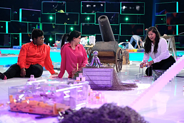 Team Wonder Women work on their fantasy movie-themed domino topple on the set of “Domino Masters,” from left are Niasia Williams, Farah Bajwa and Brianne Martin.