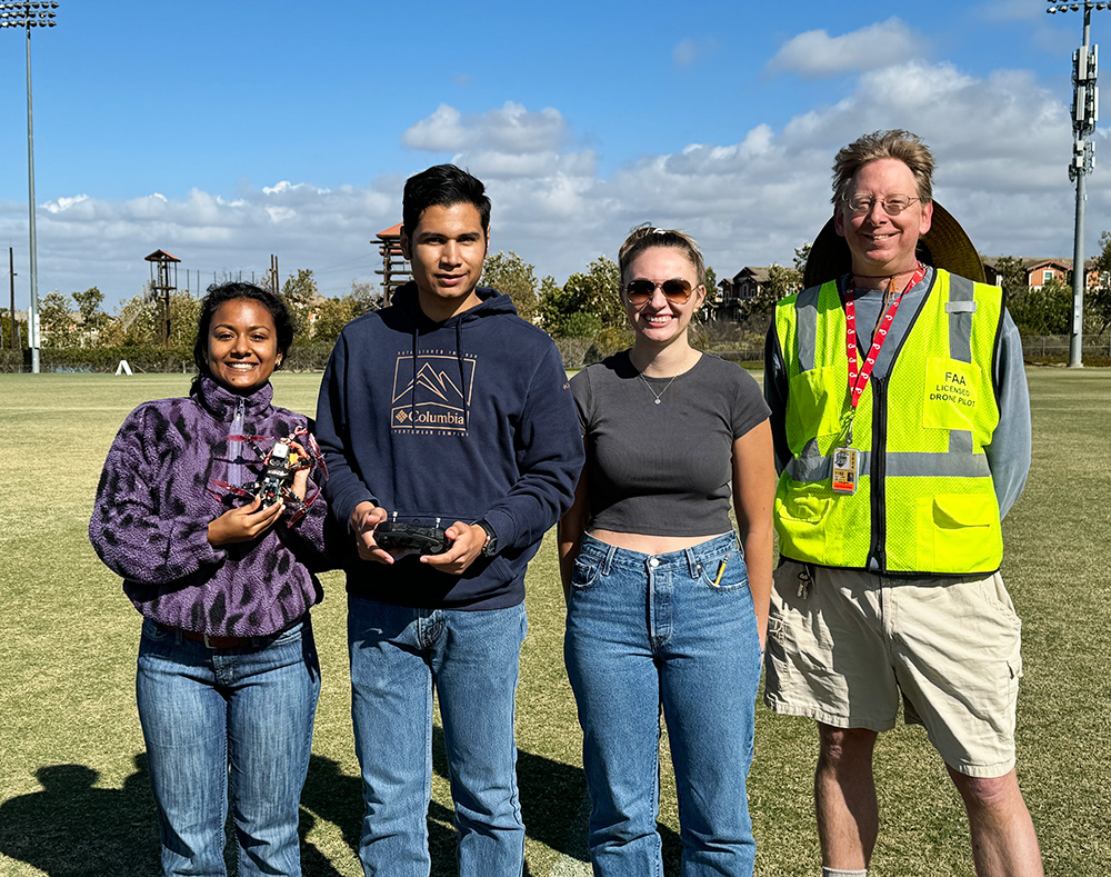 From left: Engineering students Antara Kundu, Ricardo Martinez and Catherine Riker with Professor Peter Burke after the students successfully flew their drone.