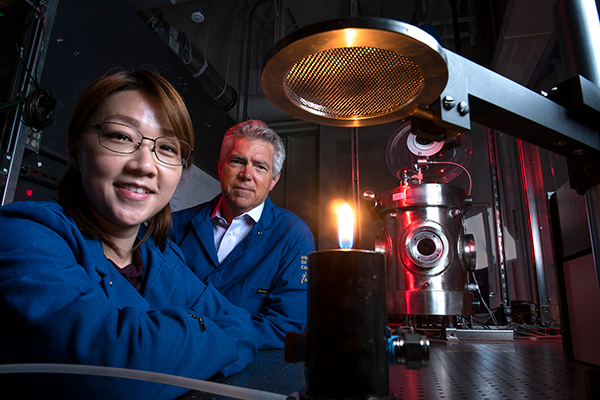 Mechanical and aerospace engineering project scientist Yu-Chien (Alice) Chien and Derek Dunn Rankin work to better understand the chemistry of flame, which in turn can help scientists explore ways to reduce pollution. Steve Zylius / UCI