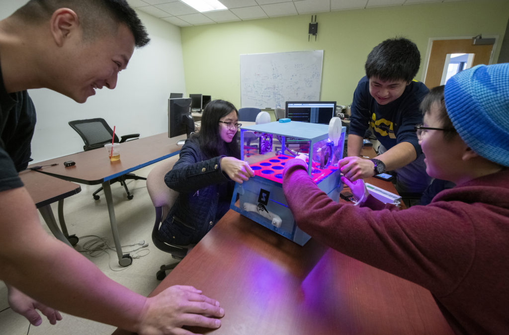 Faculty mentor Quoc-Viet Dang looks on as ZotPonics team members Kathy M. Nguyen, Owen Kai Yang and Sidney Lau (from left) show off the automated indoor hydroponics system they developed for growing food in an urban environment. Steve Zylius / UCI