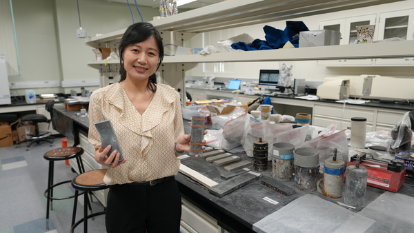 Mo Li holds up self-sensing concrete in her UCI lab.