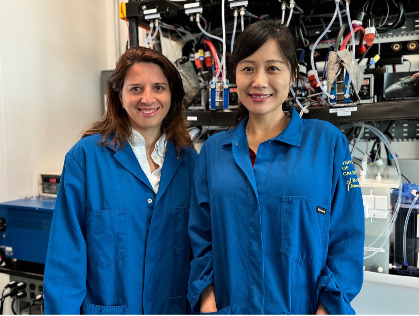 UCI National Fuel Cell Research Director Iryna Zenyuk and Mo Li, chair of the UCI civil and environmental engineering department, in front of the electrolyzer at Zenyuk’s lab.