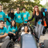 Lindsey Spindle (seated in car) and Susan Samueli pose with the Baja Racing students. 