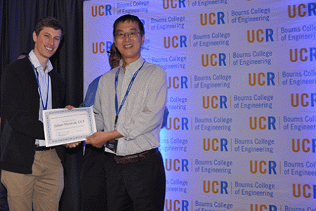 Morival (left) accepts his best poster award from Xiaoping Hu, professor and chair of UC Riverside’s Department of Bioengineering. 