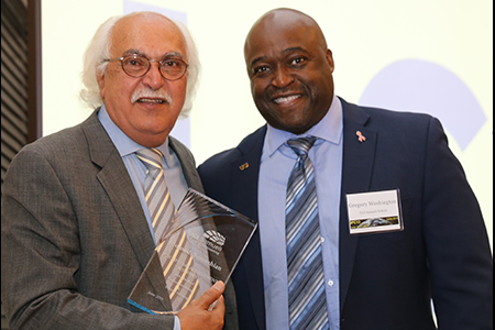 Sorooshian holds an engraved plaque from Dean Gregory Washington during his tribute dinner.