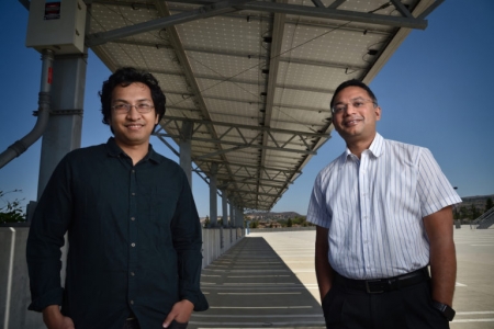 Anomadarshi Barua (left), a doctoral student in electrical engineering & computer science, and Associate Professor Mohammad Al Faruque stand within spoofing distance of a solar inverter on the UCI campus. They figured out a way to disrupt power grids using about $50 worth of equipment hidden in a disposable coffee cup. Steven Georges / UCI