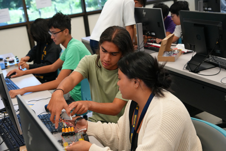 Two students working on a robotic car together