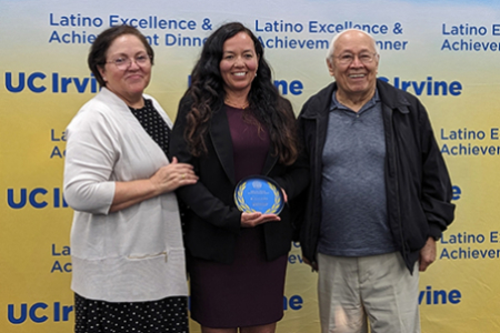 Michelle Digman (center, alongside her parents) accepts the Outstanding Faculty Mentorship Award at the 2024 Latino Excellence and Achievement Awards Dinner (LEAD).
