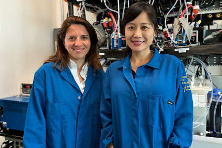 Iryna Zenyuk (left) and Mo Li in front of an electrolyzer at the National Fuel Cell Research Center.