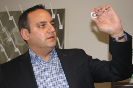 Dr. Arash Kheradvar holds a model of a heart valve used in his research to advance cardiovascular science.