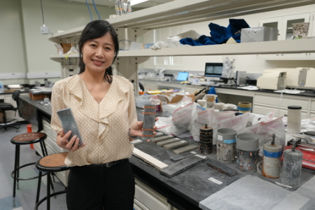 Mo Li holds up self-sensing concrete in her UCI lab.