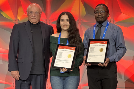 Electrical engineering and computer science graduate students Anita Ghandehari (center) and Shingirirai Chakoma (right) accept the Best Paper Award on behalf of their team at the SPIE Photonics West 2025 conference.