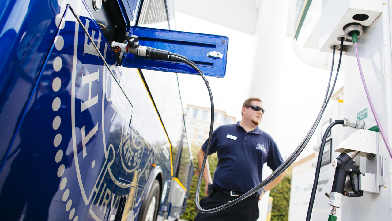 Man filling up automobile with hydrogen fuel